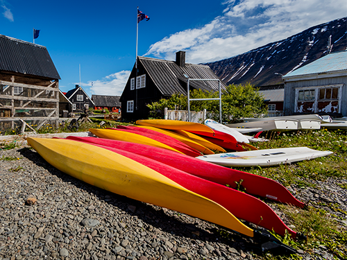Westfjords Heritage Museum fotograferet på en lys dag med farverige kanoer i forgrunden