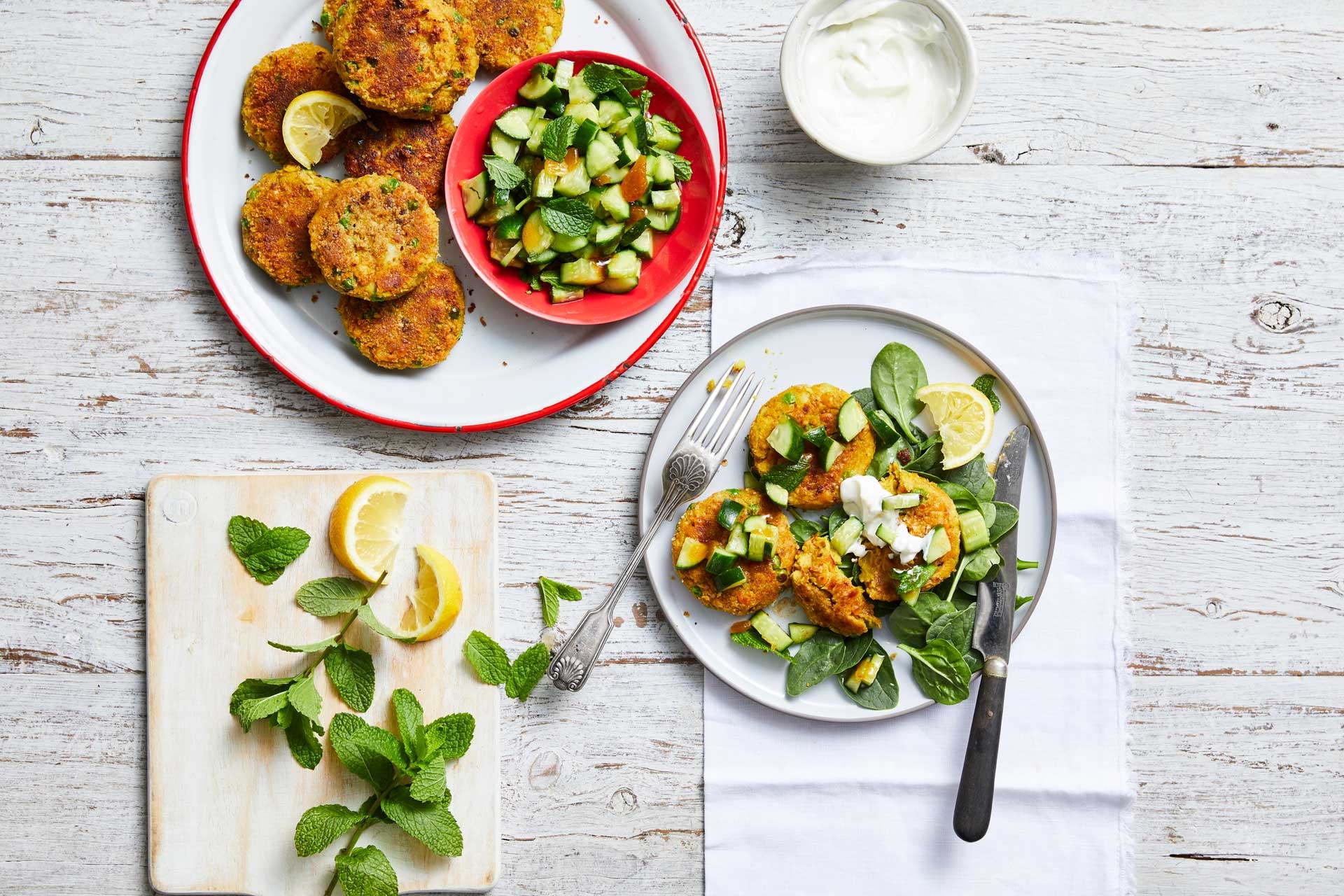 A plate of food with colorful vegetables and a bowl of creamy yogurt. A healthy and delicious meal.